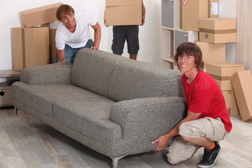 Removal team handling packed boxes and furniture in central London