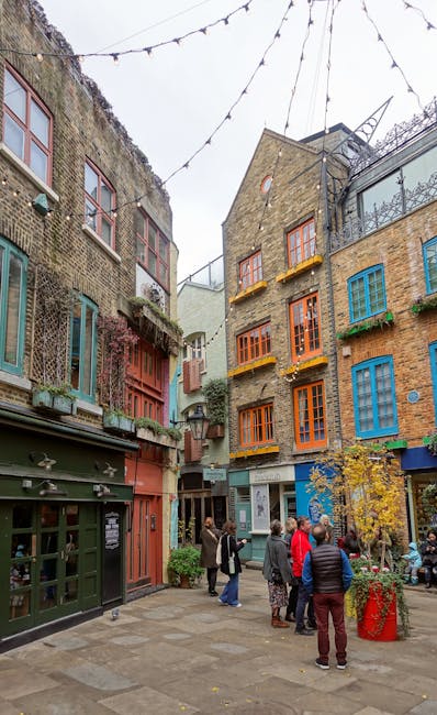 The image shows a street scene outside a retail store with a sign reading 'benefit' hanging from a white bracket attached to a brick building. Nearby, a green sign with white text indicates 'NEAL'S YA